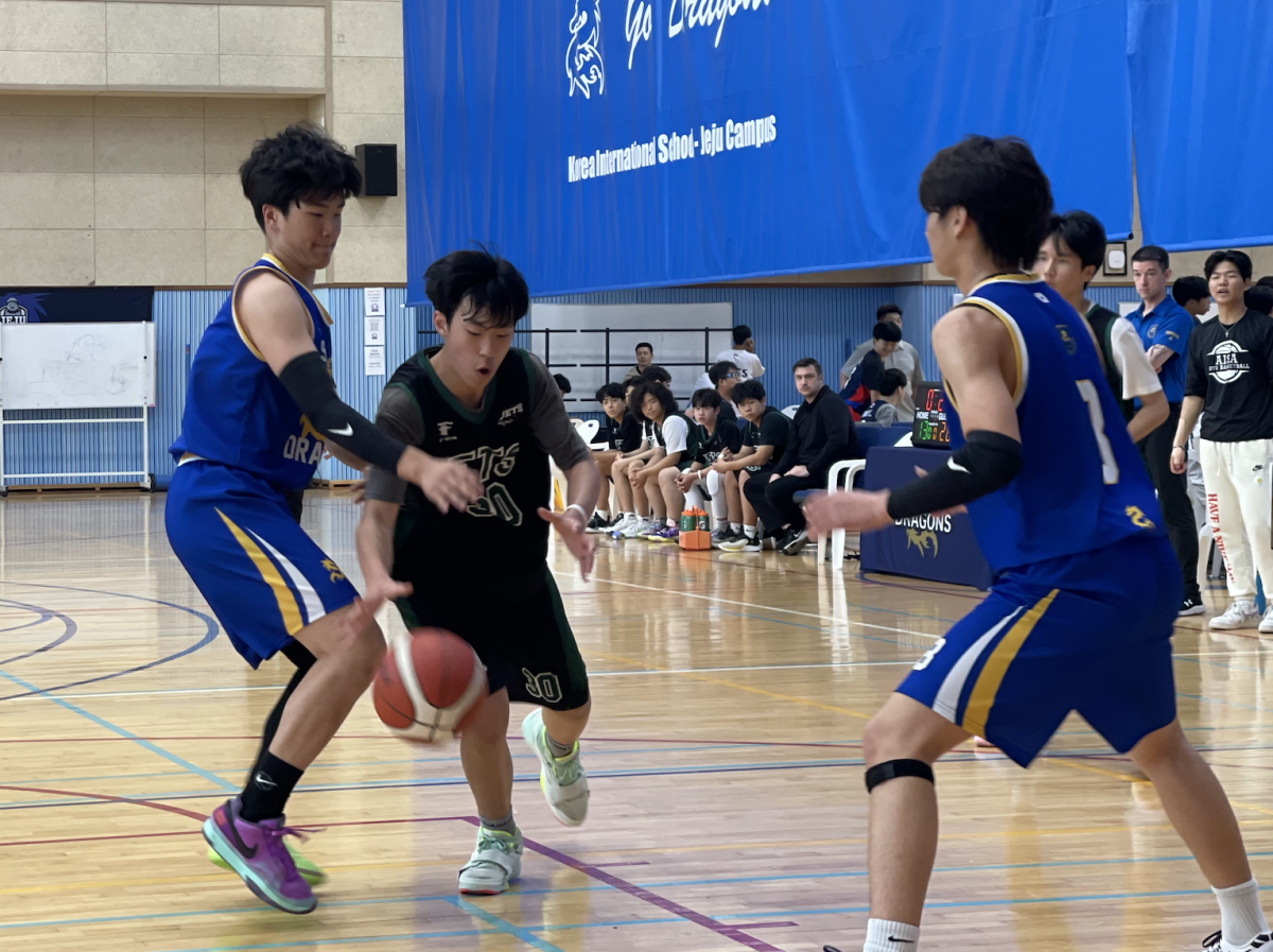 William Seo (number 30) weaves through the Dragons defense and attacks the rim. He dishes it out to the open man for a wide open three pointer.